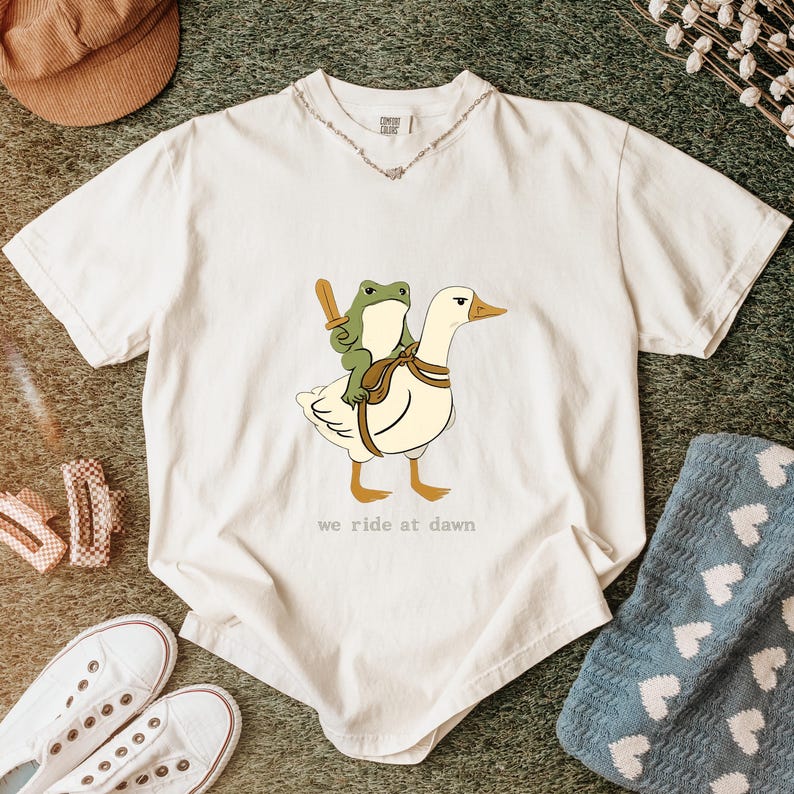 We Ride at Dawn Frog and Goose T-Shirt, Animal Graphic Tee, Vintage Whimsical Cartoon Style Top - Unisex Cotton T-Shirt, Sizes S-5XL